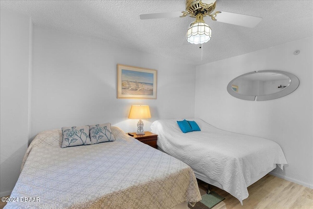 bedroom featuring a textured ceiling, light hardwood / wood-style flooring, and ceiling fan