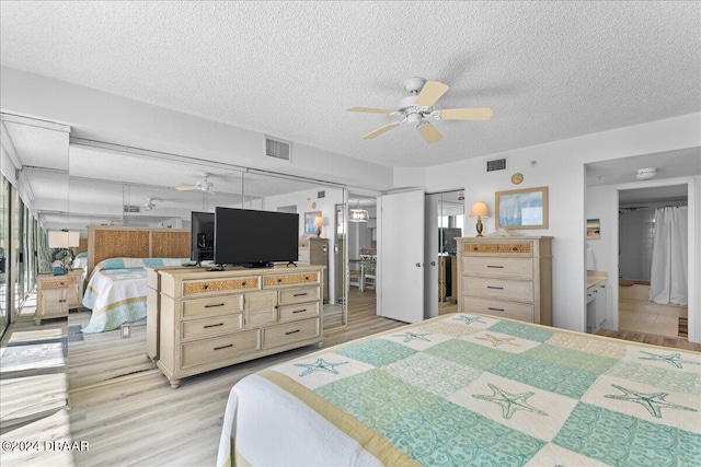 bedroom with a closet, connected bathroom, a textured ceiling, light hardwood / wood-style floors, and ceiling fan