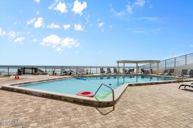 view of pool featuring a water view and a patio area