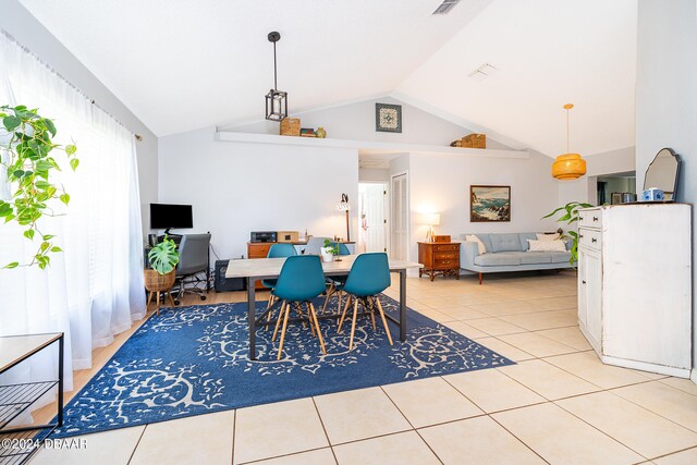 dining space featuring light tile patterned flooring and vaulted ceiling