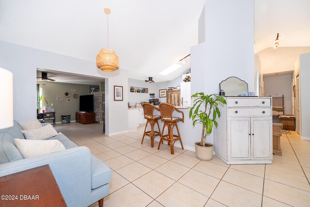 tiled living room with ceiling fan and lofted ceiling