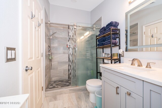 bathroom with walk in shower, vanity, and toilet