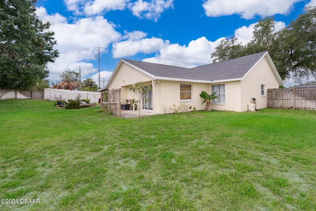 back of house featuring a yard