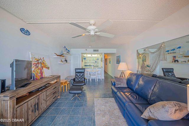 living room with ceiling fan and a textured ceiling