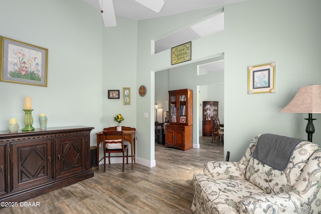 sitting room featuring hardwood / wood-style flooring, high vaulted ceiling, and ceiling fan