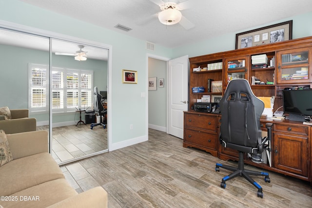 office space featuring ceiling fan, a textured ceiling, and light wood-type flooring