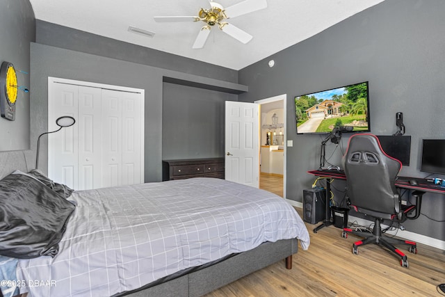 bedroom with lofted ceiling, visible vents, baseboards, a closet, and wood finished floors
