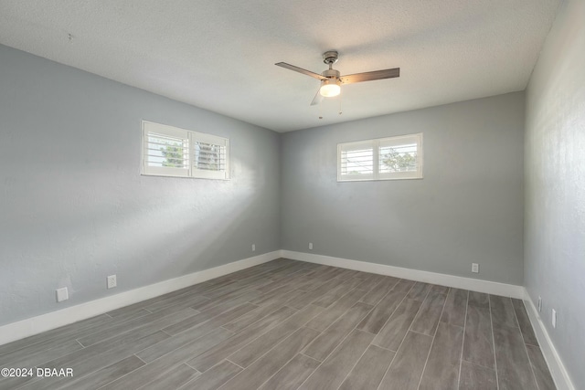 spare room with a healthy amount of sunlight, wood-type flooring, and a textured ceiling