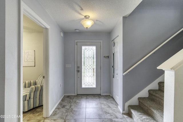 61 Levee Ln, Ormond Beach, FL 32174 - entryway featuring a textured ceiling, stairs, and light tile patterned floors