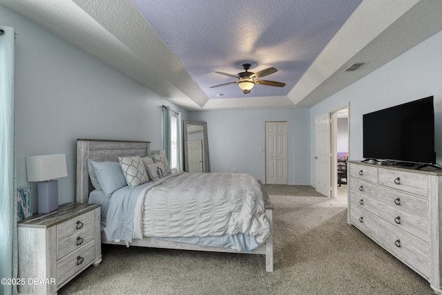 61 Levee Ln, Ormond Beach, FL 32174 - bedroom featuring carpet flooring, a tray ceiling, a closet, a textured ceiling, and ceiling fan