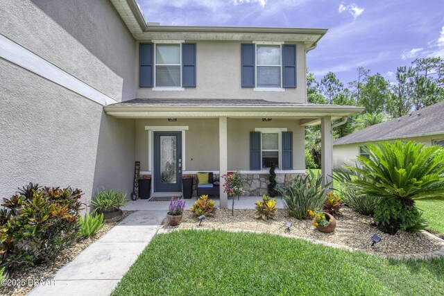 61 Levee Ln, Ormond Beach, FL 32174 - view of front of property featuring stucco siding, a porch, and a front lawn
