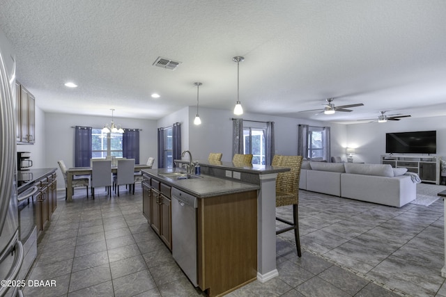 61 Levee Ln, Ormond Beach, FL 32174 - kitchen featuring stainless steel appliances, a kitchen bar, dark countertops, a ceiling fan, and a kitchen island with sink