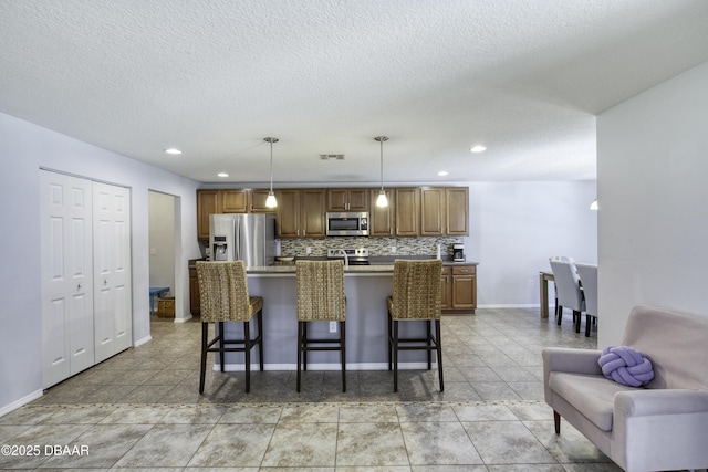 61 Levee Ln, Ormond Beach, FL 32174 - kitchen with appliances with stainless steel finishes, a breakfast bar area, tasteful backsplash, recessed lighting, and brown cabinets