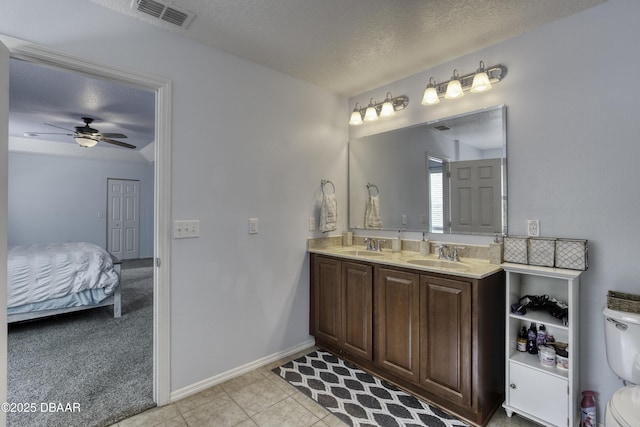 61 Levee Ln, Ormond Beach, FL 32174 - ensuite bathroom featuring a textured ceiling, double vanity, tile patterned flooring, and ceiling fan