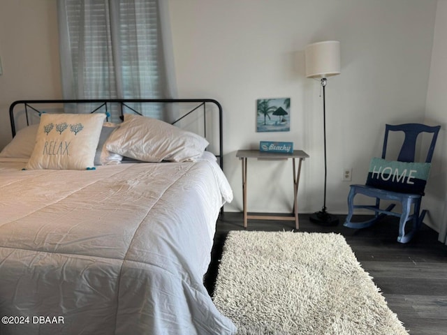 bedroom with dark hardwood / wood-style floors