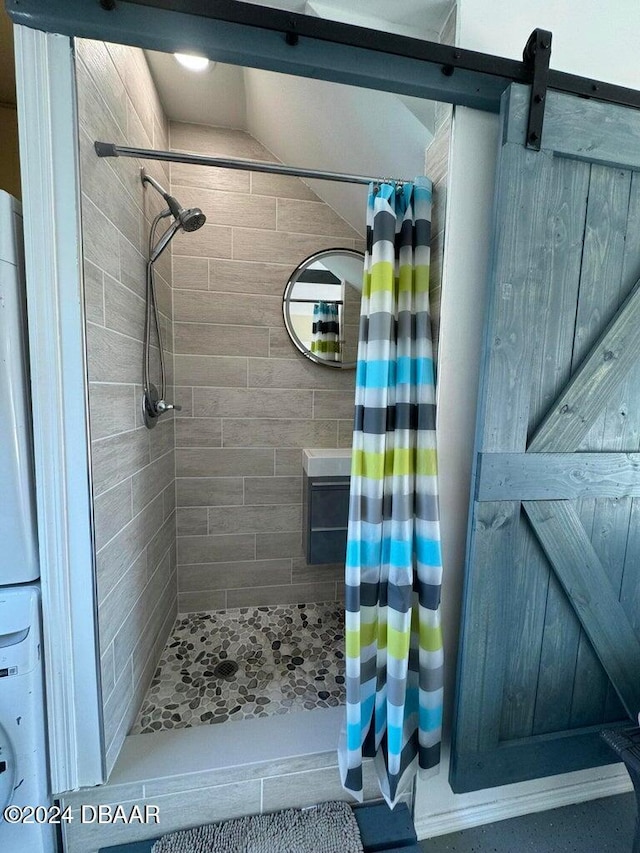 bathroom featuring stacked washer / drying machine and walk in shower