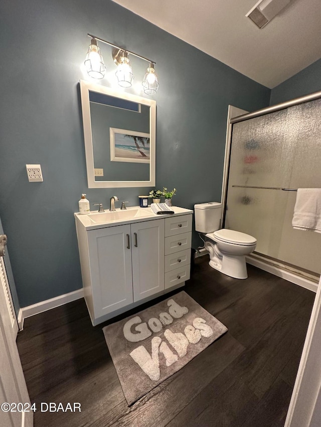 bathroom featuring vanity, a shower with door, hardwood / wood-style flooring, toilet, and lofted ceiling