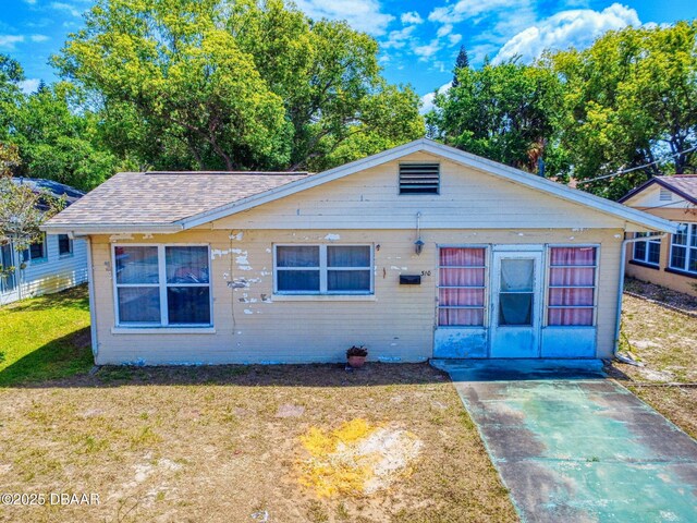 310 Legion Pl, Port Orange, FL 32129 - bungalow-style home with a shingled roof and a front lawn