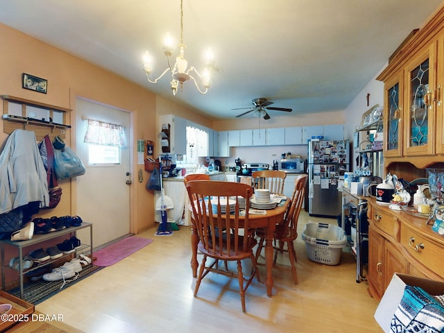 310 Legion Pl, Port Orange, FL 32129 - dining area with light wood-style floors and ceiling fan with notable chandelier