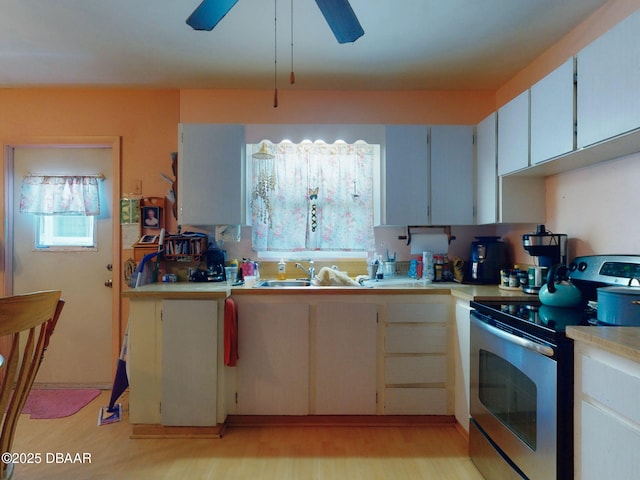 310 Legion Pl, Port Orange, FL 32129 - kitchen featuring a sink, stainless steel electric range oven, light wood-type flooring, a ceiling fan, and light countertops