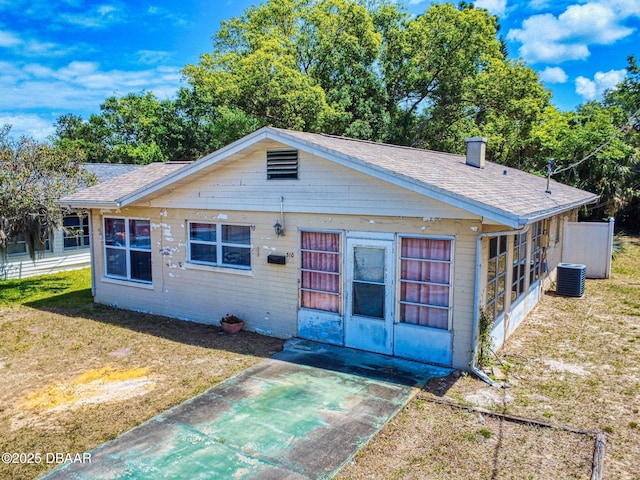 310 Legion Pl, Port Orange, FL 32129 - bungalow-style house with a front yard, a patio, a shingled roof, and central AC unit