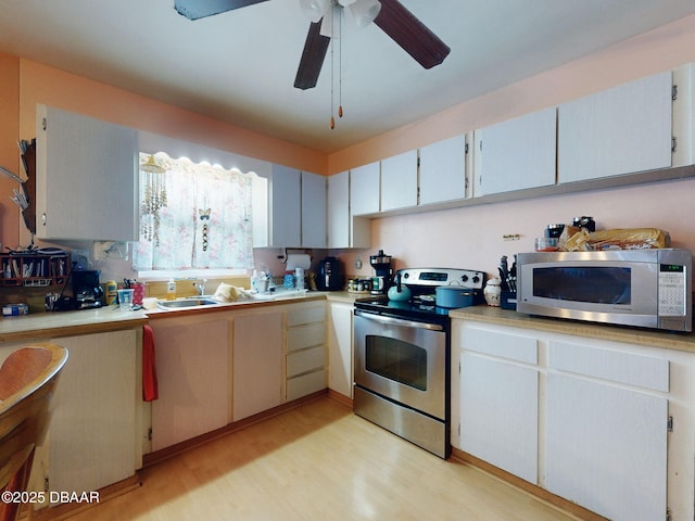 310 Legion Pl, Port Orange, FL 32129 - kitchen with light wood-style flooring, stainless steel appliances, light countertops, ceiling fan, and a sink
