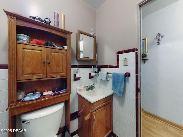 310 Legion Pl, Port Orange, FL 32129 - bathroom featuring tile walls, vanity, toilet, wainscoting, and wood finished floors