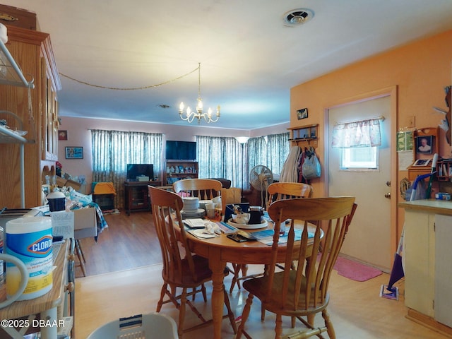 310 Legion Pl, Port Orange, FL 32129 - dining room with light wood-type flooring, a notable chandelier, and a healthy amount of sunlight