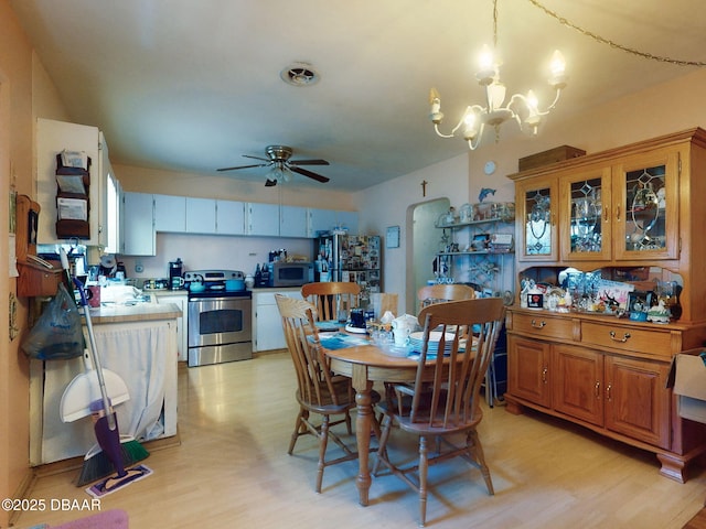 310 Legion Pl, Port Orange, FL 32129 - dining space featuring light wood-type flooring, arched walkways, and ceiling fan with notable chandelier