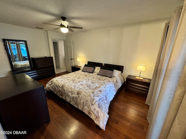 bedroom with a textured ceiling, dark hardwood / wood-style flooring, and ceiling fan