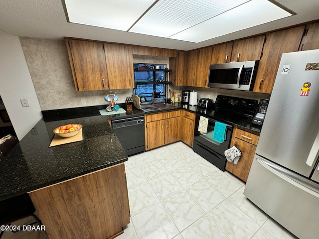 kitchen with black appliances, sink, and dark stone countertops