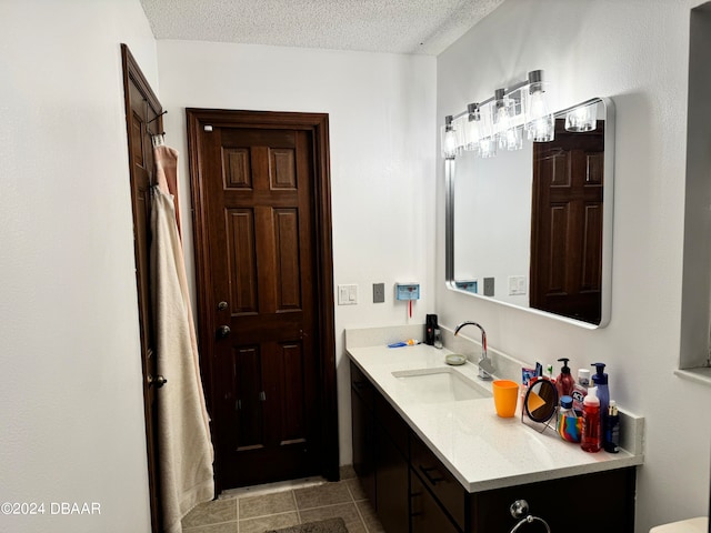 bathroom with vanity, a textured ceiling, and tile patterned floors