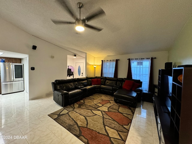 living room featuring a textured ceiling, vaulted ceiling, and ceiling fan