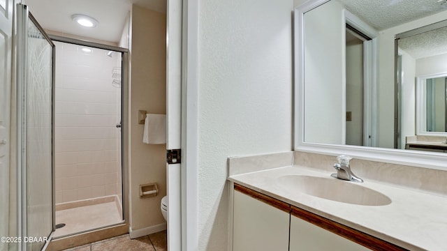 4655 46th Street Ct W Unit 101, Bradenton, FL 34210 - bathroom with a shower stall, vanity, a textured ceiling, and tile patterned floors
