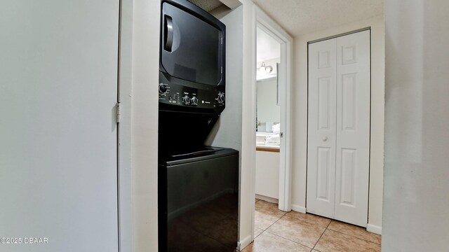 4655 46th Street Ct W Unit 101, Bradenton, FL 34210 - washroom featuring stacked washing machine and dryer and light tile patterned floors