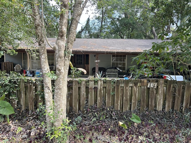 exterior space with fence and roof with shingles