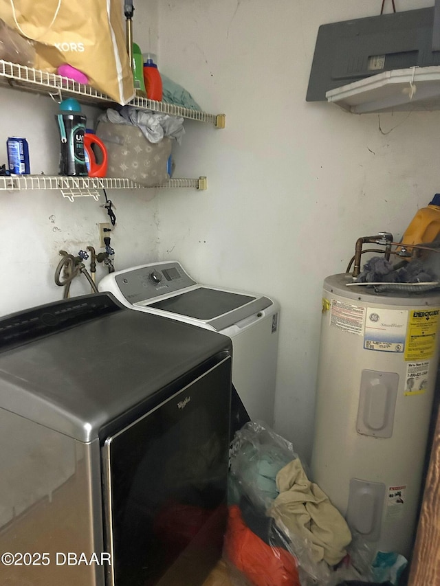 clothes washing area featuring separate washer and dryer, laundry area, and electric water heater