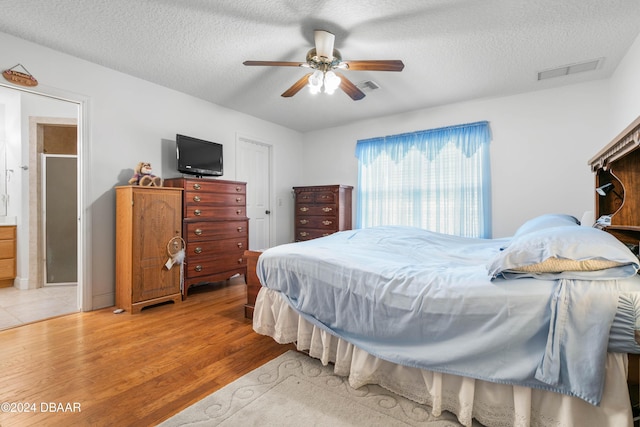 bedroom featuring ceiling fan, a textured ceiling, and light hardwood / wood-style flooring