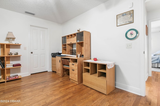 interior space featuring light hardwood / wood-style floors and a textured ceiling