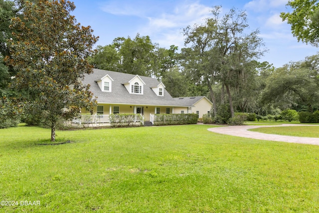 cape cod-style house featuring covered porch and a front lawn