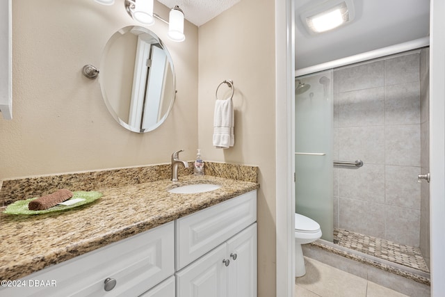 bathroom with tile patterned flooring, vanity, toilet, and a shower with door