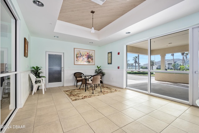 tiled dining space with a raised ceiling and wood ceiling