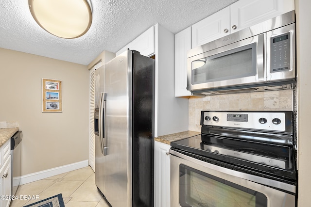 kitchen with white cabinetry, light tile patterned floors, a textured ceiling, and appliances with stainless steel finishes