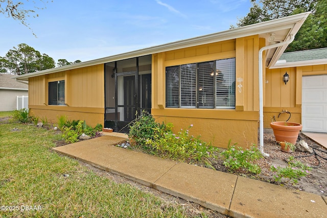 property entrance with a lawn