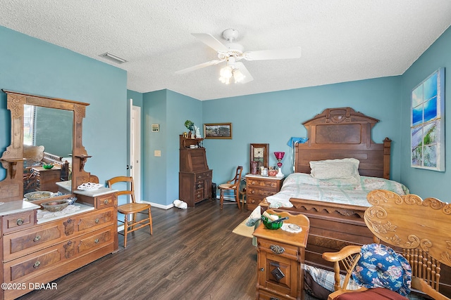 bedroom featuring dark wood-type flooring, a textured ceiling, and ceiling fan