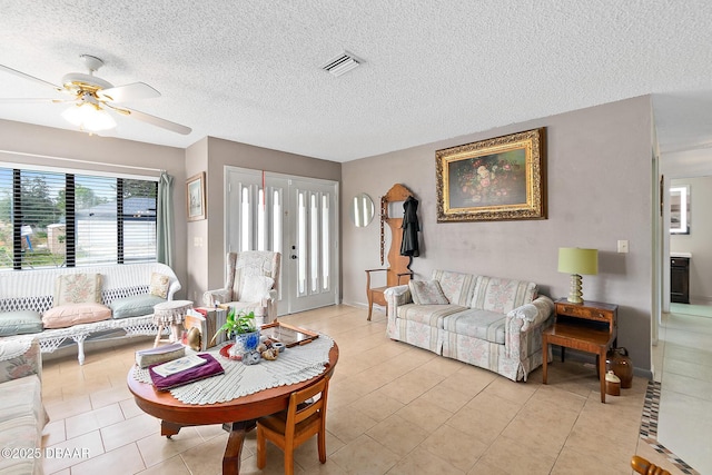 tiled living room featuring ceiling fan and a textured ceiling