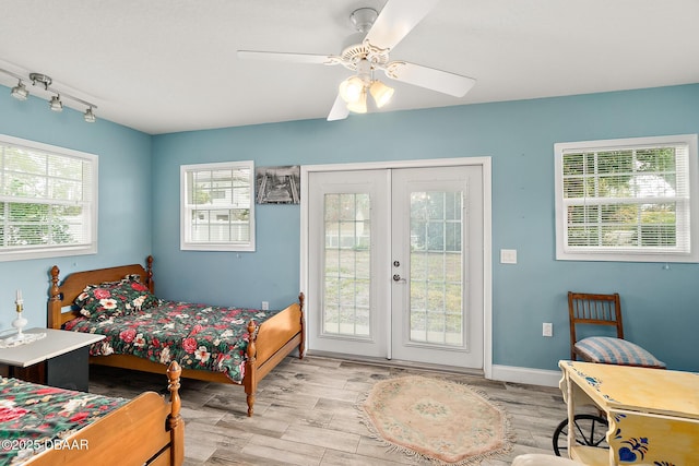 bedroom with rail lighting, access to outside, ceiling fan, and french doors