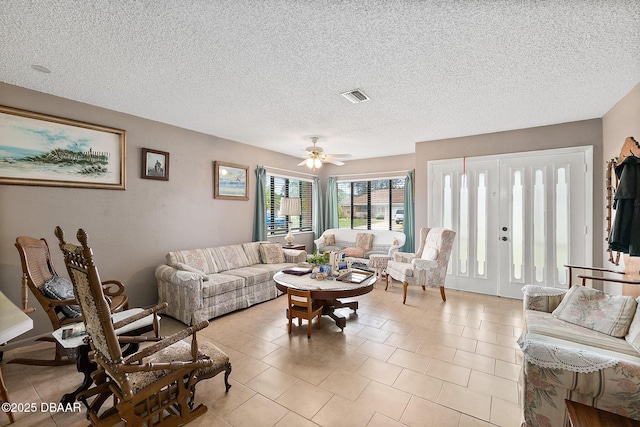 tiled living room featuring ceiling fan and a textured ceiling