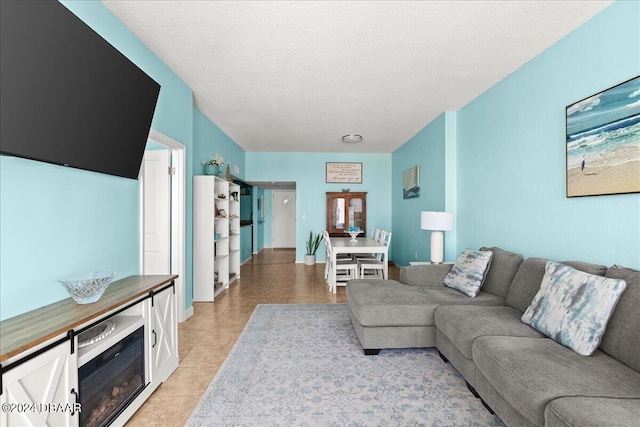 living room with a textured ceiling and light tile patterned floors