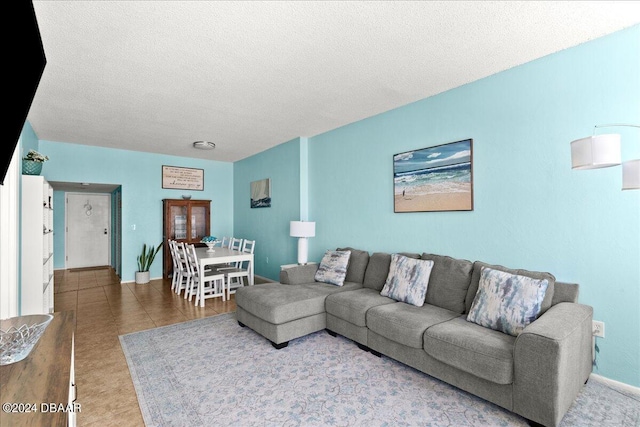 tiled living room featuring a textured ceiling